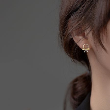 A single gold-plated 925 silver bow earring on a clean white background.