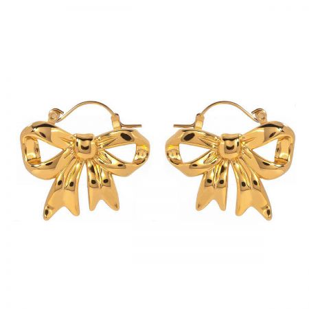 Close-up detail of the gold bow earring's hinged hook mechanism.