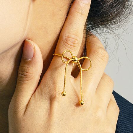 A model wearing the gold PVD bowknot ring to showcase its fit and style.
