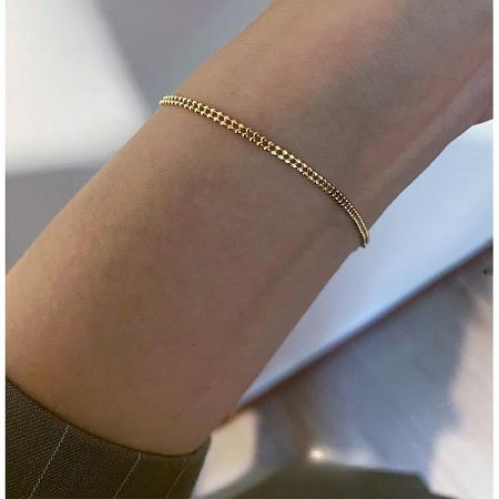 Close-up of the 14K gold plated sterling silver bracelet on a wrist.