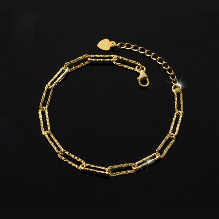 Close-up of the gold paper clip bracelet showing its textured links and heart charm.