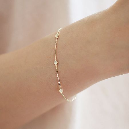 Model wearing the gold zircon disc bracelet to show scale and style.