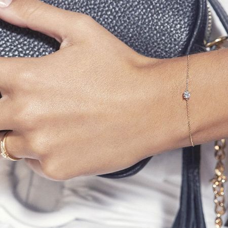 Detailed view of the gold thin chain bracelet with its sparkling cubic zirconia centerpiece.