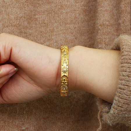 Women's Stainless Steel 18k Gold Open Cuff Sun and Moon Bracelet Bangle Set of 5 - A close-up of the 18k gold-plated stainless steel bracelet from the sun and moon set, featuring intricate celestial designs with white cubic zirconia accents.