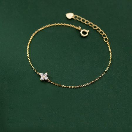 Detailed view of the gold-plated four-leaf clover charm bracelet.
