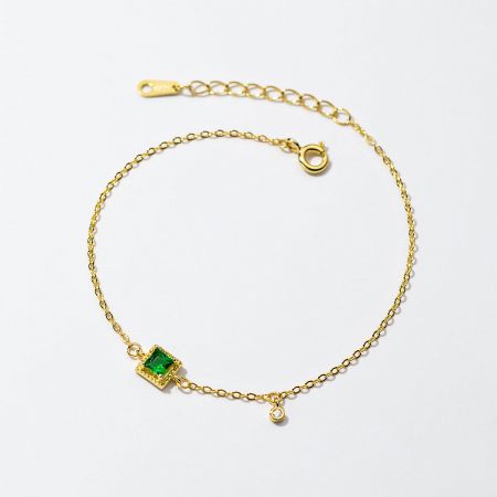 Detailed view of the 18k gold plated bracelet with green and white zircon stones.