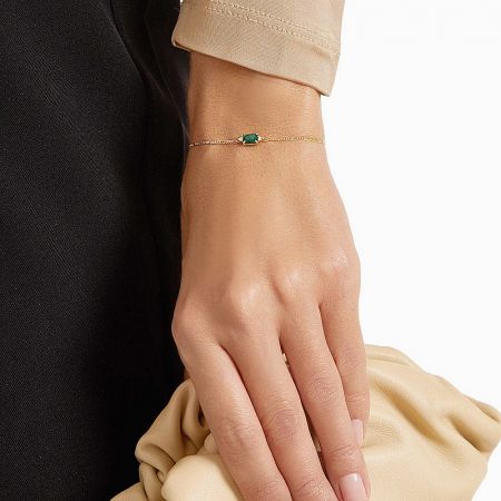 The 925 sterling silver bracelet with green gemstone displayed on a neutral background to highlight its gold finish.