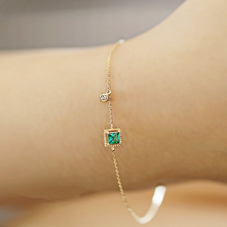 Wholesale 925 Sterling Silver Gold-Plated Green Emerald Zircon Bracelet Set of 5 - Close-up of a 925 sterling silver gold-plated bracelet featuring a square green emerald zircon and a small clear gemstone.