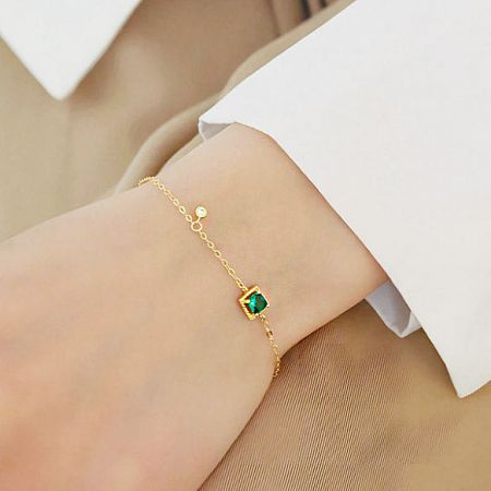 Model wearing the 925 sterling silver gold-plated green zircon bracelet to show scale.