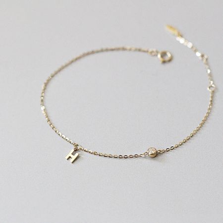 Alternate angle of the H charm bracelet, showing the clasp and circular charm.