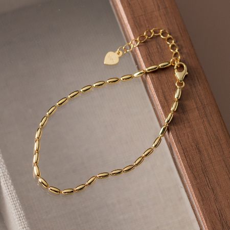 Detailed view of the gold-finished rice beaded bracelet, highlighting its polished beads and secure clasp.