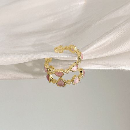 Full view of the gold bracelet featuring multiple pink heart gemstones.