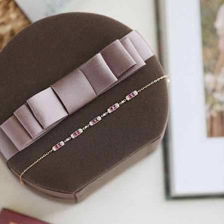 Detailed view of the delicate link chain and vibrant pink ruby on the sterling silver bracelet.