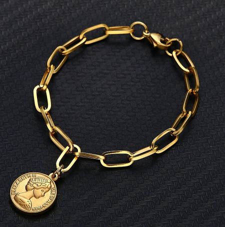 Close-up of the Queen Elizabeth II coin pendant on the gold charm bracelet.