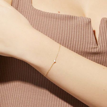 Close-up of the gold opal bracelet on a person's arm.