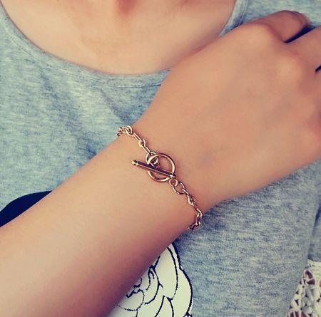 Model wearing the gold stainless steel toggle bracelet to show its fit and style.
