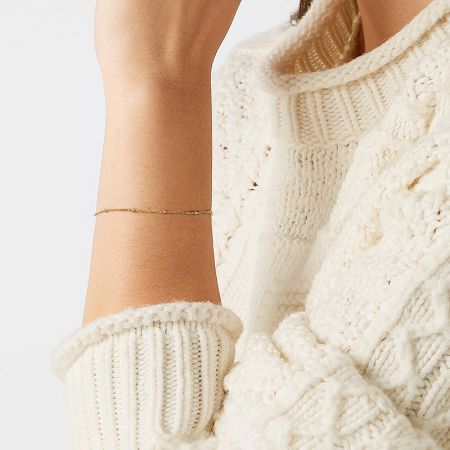 A stylish look featuring the gold sterling silver bead bracelet paired with a cozy sweater.