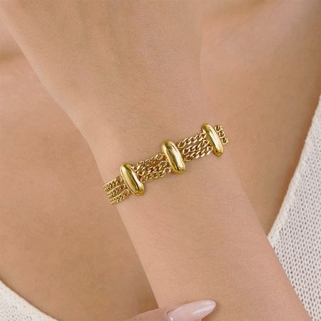 Model showcasing the modern style of the layered gold bracelet set.