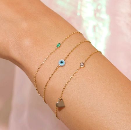 A collection of stylish gold charm bracelets from JR Fashion Accessories, showcasing various designs.