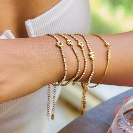 Close-up view of the stainless steel initial bracelets, highlighting the detailed alphabet charms.