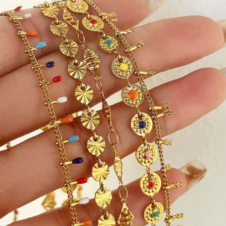 Assortment of matching gold bracelets adorned with colorful gemstones, showcasing the collection's style.