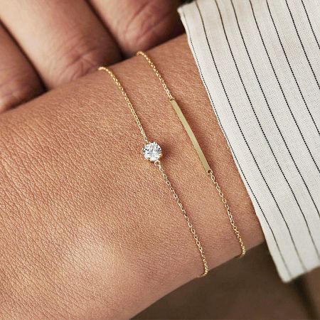 Model wearing the gold single cubic zirconia thin chain bracelet, showing its delicate design on the wrist.