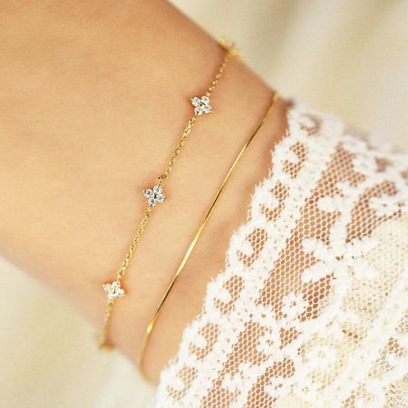 A model wearing multiple bracelets from the starry clover set to showcase layering options.