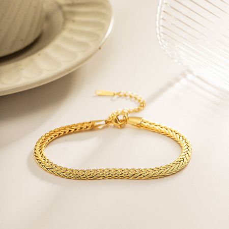 Detailed view of the curb chain bracelet's clasp and high-quality gold finish.