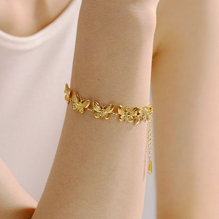 Detailed view of the butterfly charm on the stainless steel bracelet.