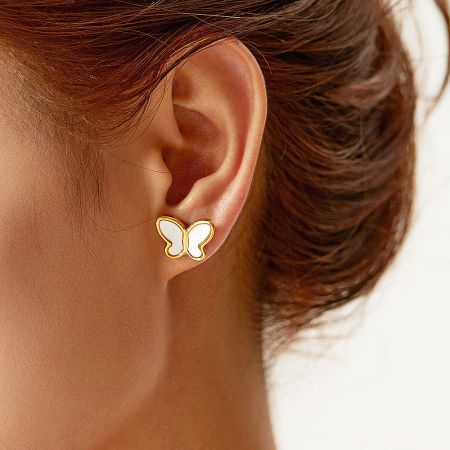 Close-up view of a woman wearing the gold mother of pearl butterfly stud earring.
