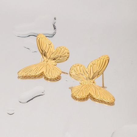 Another angle of the gold butterfly earrings, highlighting their shiny finish.