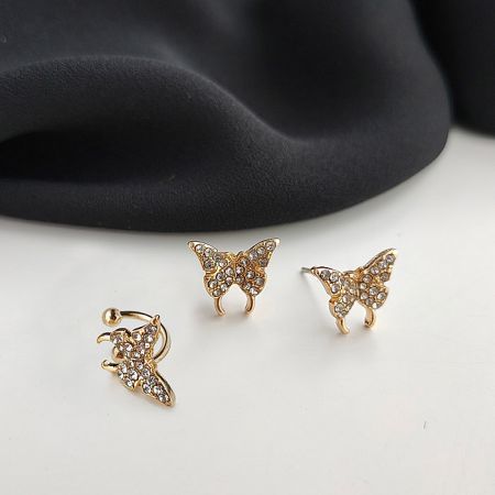 Detailed view of the gold butterfly stud earrings, showcasing the intricate arrangement of clear gemstones.