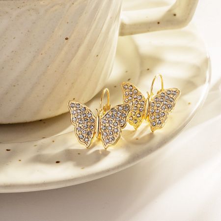 The pair of gold butterfly drop hook earrings displayed together to show their elegant design.