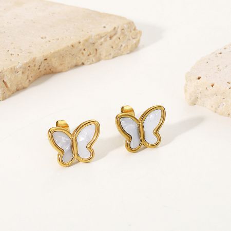 Detailed shot of the gold butterfly earrings highlighting the white mother of pearl inlays.