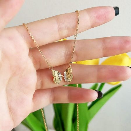 A clear product shot of the gold butterfly necklace, showing its elegant design.