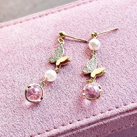 Full view of the gold butterfly and pearl earrings against a white background.