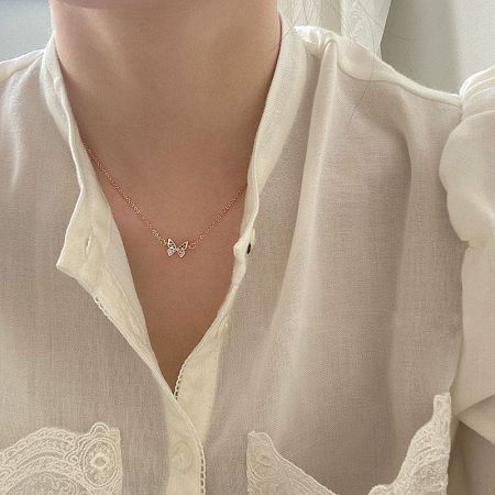 Model wearing the sterling silver butterfly necklace in rose gold finish.