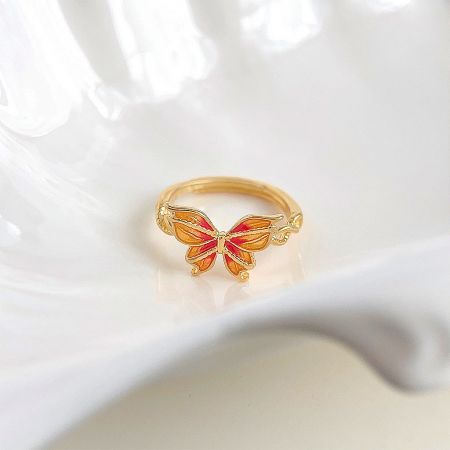 Side view of the gold-plated enamel butterfly ring, showing the adjustable band.
