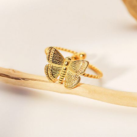 Product shot of the gold butterfly ring showing textured details.