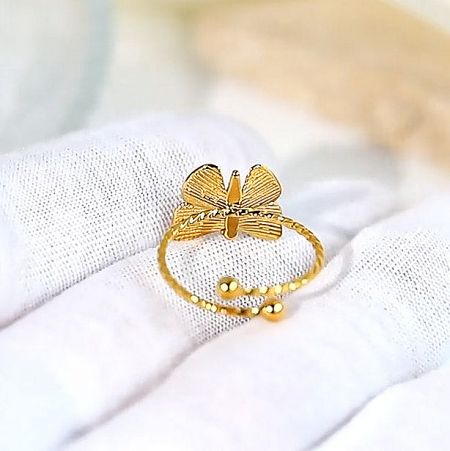 Close-up of the gold butterfly ring highlighting the textured wings.