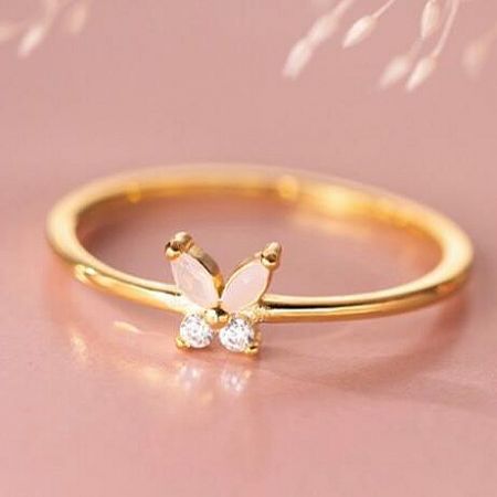 Elegant gold butterfly ring featuring delicate pale pink and clear gemstones.