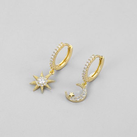 Detailed view of the gold celestial-themed huggie hoop earrings with star and moon charms.