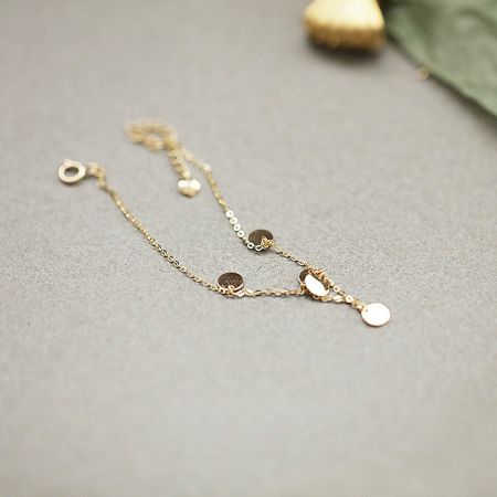 A delicate gold chain bracelet with various charms, included in the sterling silver set.
