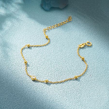 The gold version of the bead chain bracelet, featuring a clear zircon stone.