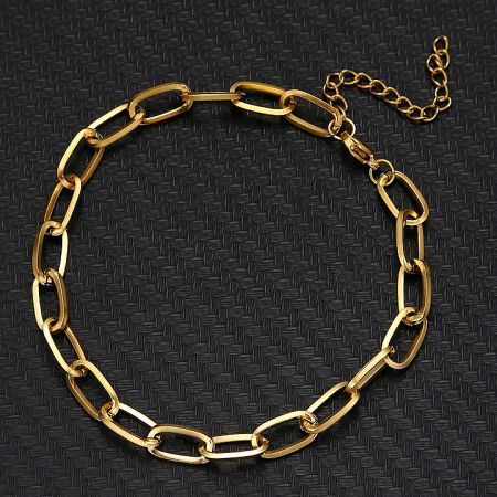 Detailed view of the gold bracelet's chain links and lobster clasp.