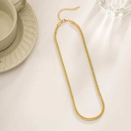 The gold rope chain necklace coiled to show its texture and shine.