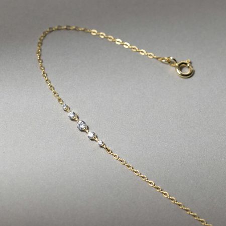 Close-up of a gold-plated chain bracelet from the set, highlighting the brilliant gemstone accents.