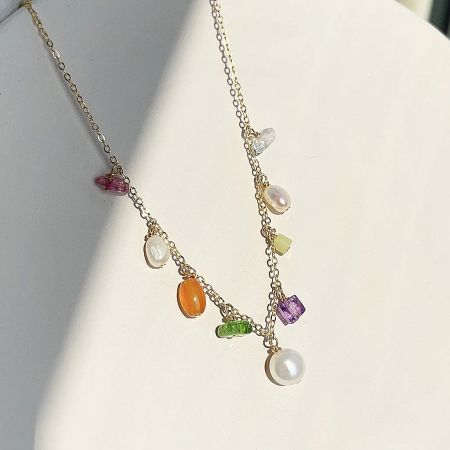 Fashion Brass Necklace Set with Color Stone Beads and Pearl Charm - A close-up of a fashion brass necklace set featuring a gold chain with vibrant, multicolored gemstones and a delicate pearl charm, displayed on a neutral background.