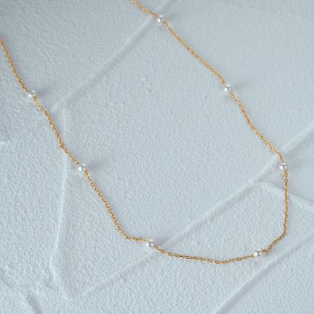 Detailed view of the delicate gold chain and 3mm pearl accents.