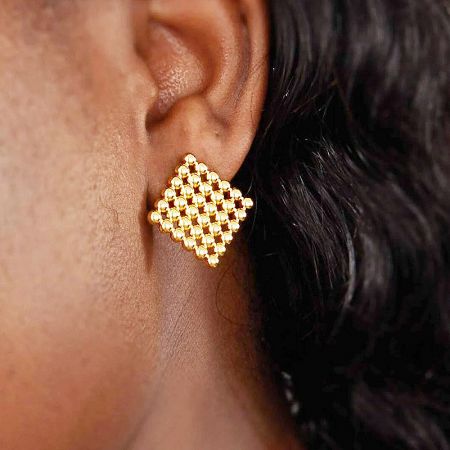 A model wearing the square gold-plated stud earring, showcasing its size and appearance.